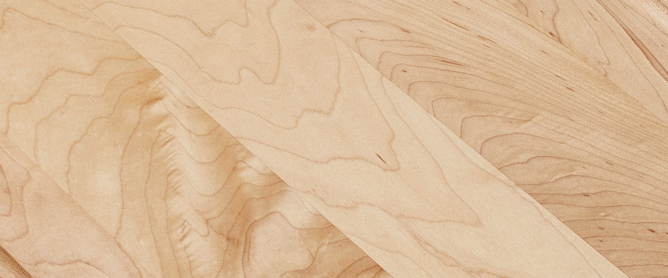 Close-up of a maple wood cutting board with visible grain and texture.