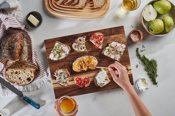 Person drizzling honey on delicious fresh toast on motley walnut wood serving board by sonder los angeles