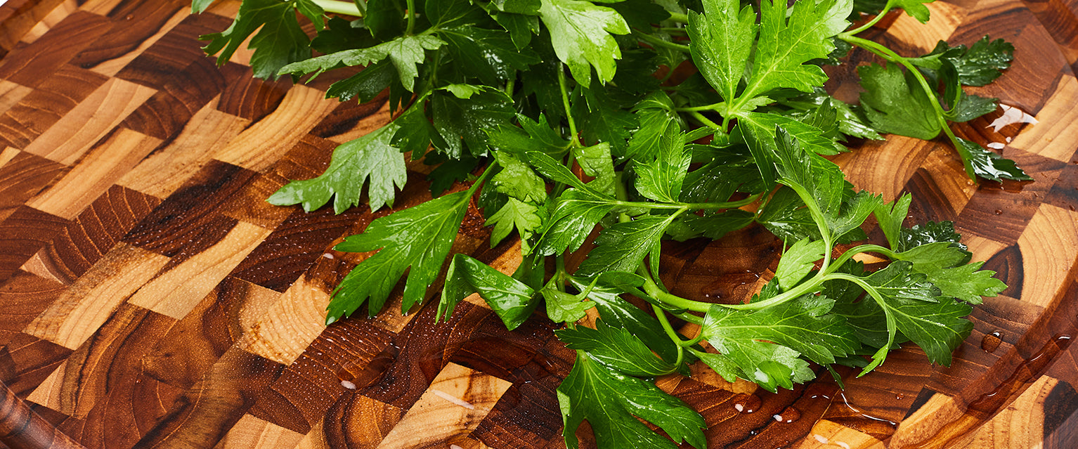 Fresh green parsley on a teak end grain wooden cutting board