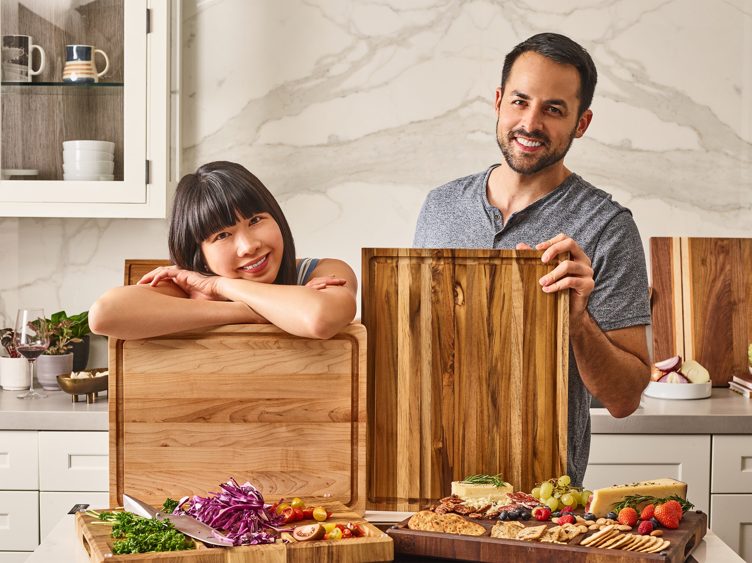 Founders Tiffany and Tarek in a kitchen with wooden cutting boards and food.