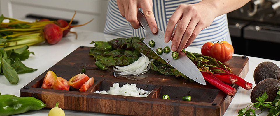 a person chopping jalapeños on an Sonder LA cutting board