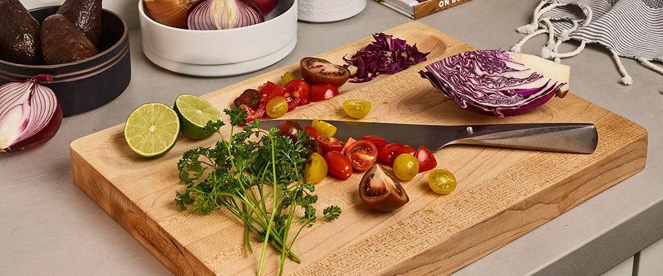 Sonder LA wooden cutting board with vegetables and a knife on a kitchen counter