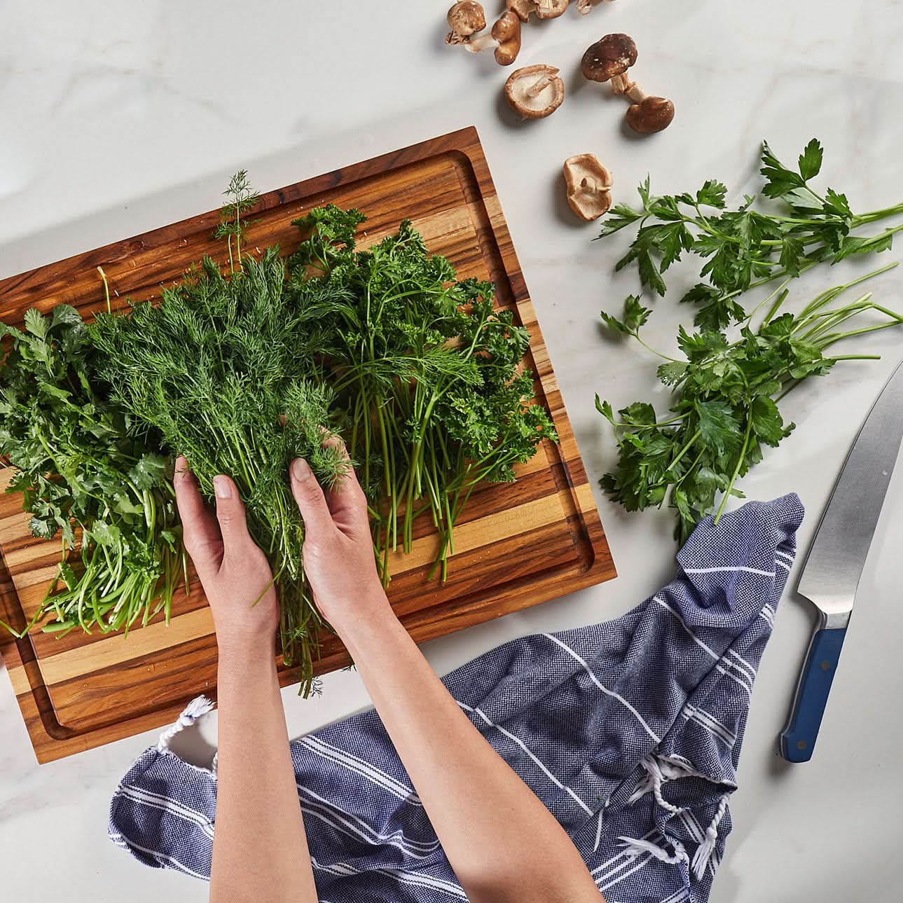 Sonder Los Angeles Large Teak Wood Laurel Cutting Board with Herbs on Countertop