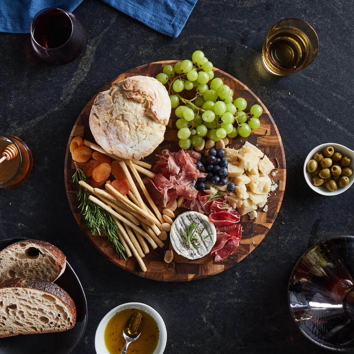 Beautifully styled charcuterie on a round end grain teak wood cutting board by Sonder Los Angeles