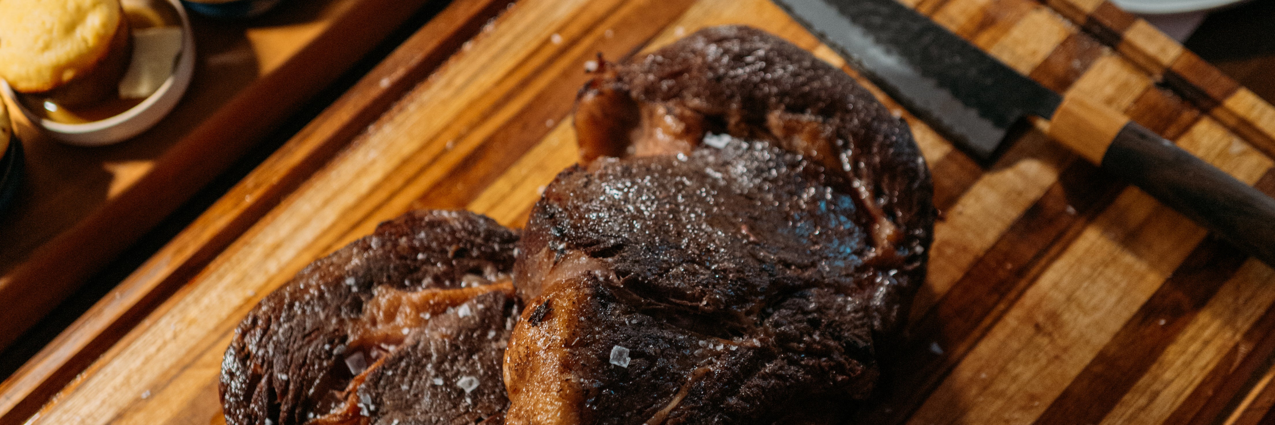 Two steaks on Highland Teak cutting board.