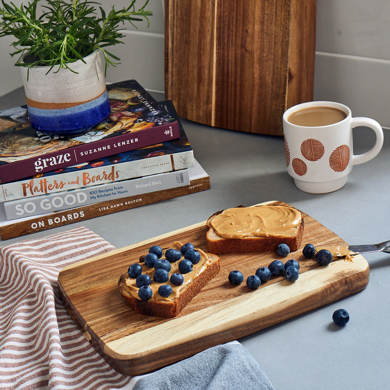 Small acacia wood cutting board by Sonder Los Angeles, used as a breakfast plate for peanut butter and blueberry toast
