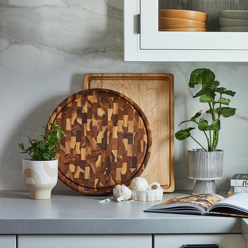 Round End Grain Teak Butcher Block and Maple Cutting Board Styled in a Modern White Kitchen